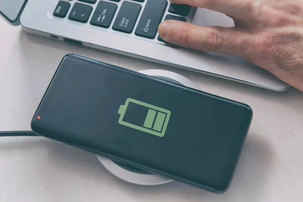 Smartphone on a wireless charging pad, charger.