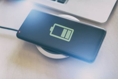 Akıllı telefon kablosuz şarj cihazına yükleniyor.