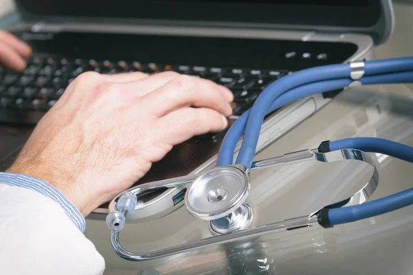 Medico digitando sul computer portatile — Foto Stock