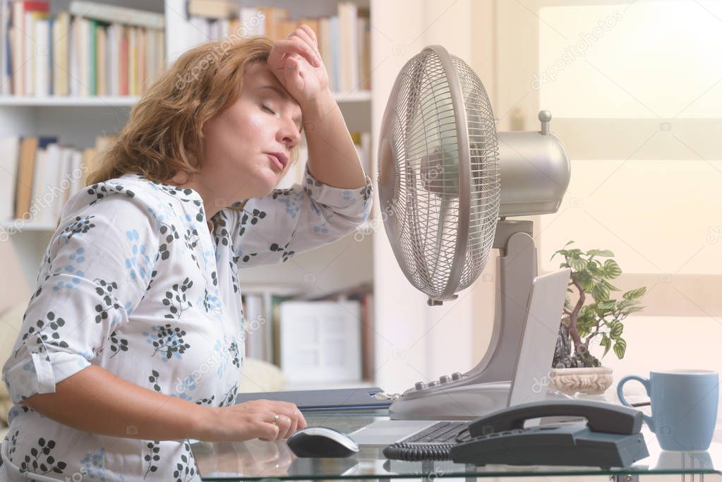 Woman suffers from heat in the office or at home