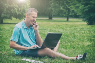 Adam parkta onun laptop ile çalışan