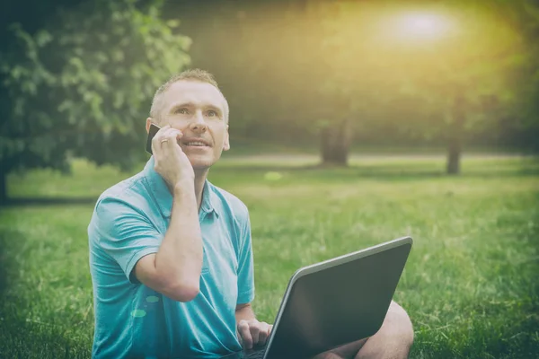 Homme travaillant avec son ordinateur portable dans le parc — Photo