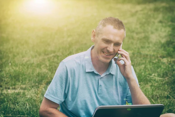 Homme travaillant avec son ordinateur portable dans le parc — Photo