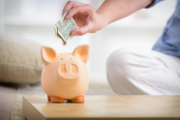 Saving money in the piggybank — Stockfoto