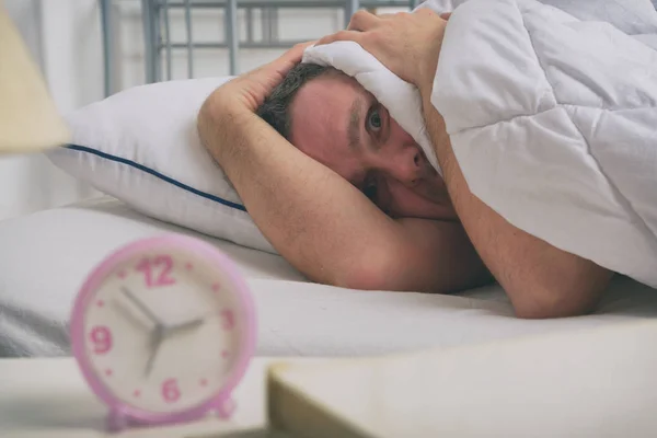Slapeloze man in zijn bed — Stockfoto