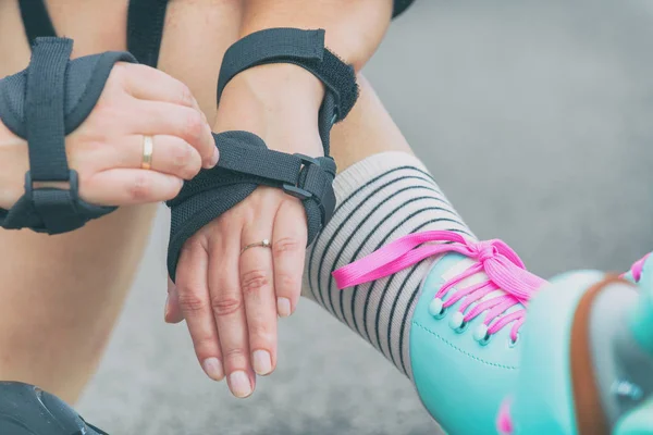 Woman rollerskater putting on wrist guards protector pads — 스톡 사진