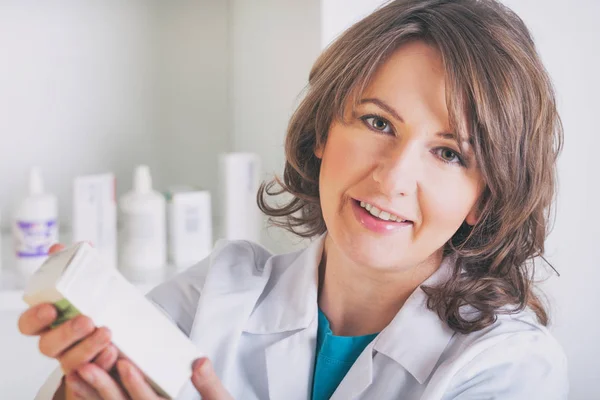 Farmacista che mostra un medicinale in farmacia — Foto Stock