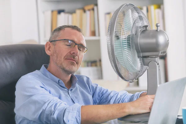 L'homme souffre de chaleur au bureau ou à la maison — Photo