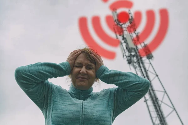 Woman is holding her head near the 5G BTS — Stock Photo, Image