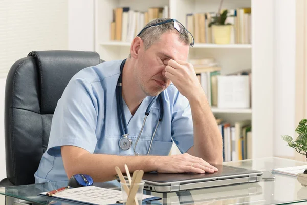 Überlasteter Arzt in seinem Büro — Stockfoto