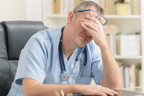 Médico con exceso de trabajo en su consultorio —  Fotos de Stock