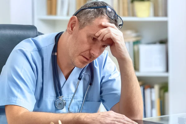 Überlasteter Arzt in seinem Büro — Stockfoto