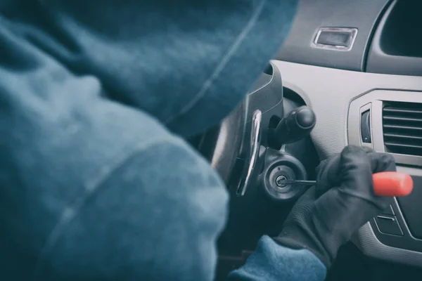 Ladrón encapuchado se sienta en el coche y trata de romper el swi de encendido —  Fotos de Stock