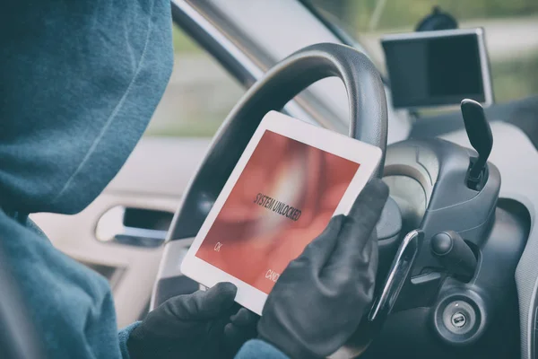 Kapuzendieb versucht Sicherheitssysteme des Autos mit Tablett aufzubrechen — Stockfoto