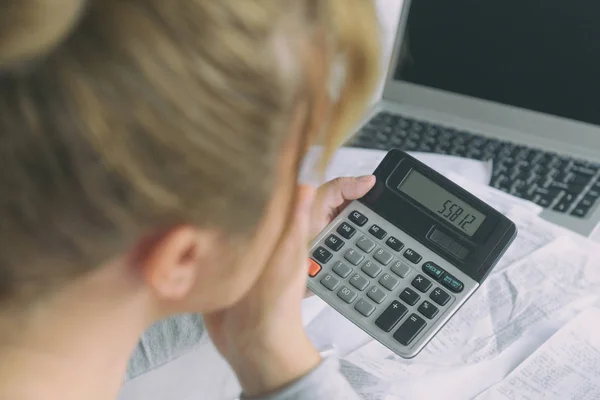 Mujer utiliza una calculadora para sumar los gastos en casa —  Fotos de Stock