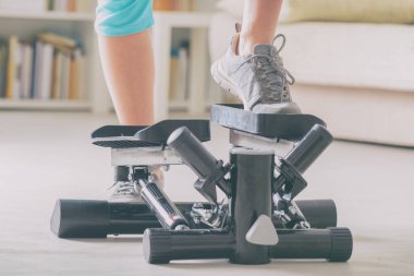 Kadın, evde adım atma egzersizi yapıyor.