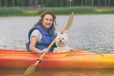 Güzel bir kadın köpeğiyle gölün karşısına geçiyor.