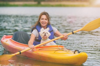 Güzel bir kadın köpeğiyle gölün karşısına geçiyor.