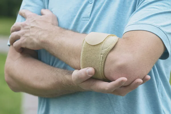 Man Bär Armbåge För Att Minska Smärta — Stockfoto