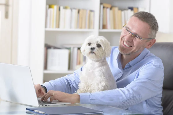 Een Man Die Thuis Werkt Zijn Hond Vasthoudt — Stockfoto
