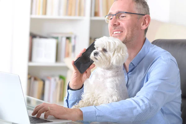 Een Man Die Thuis Werkt Zijn Hond Vasthoudt — Stockfoto