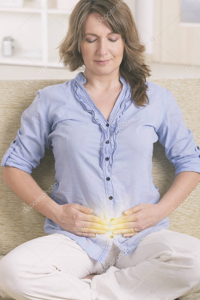 Woman practicing self Reiki transfering energy through palms, a kind of energy medicine.
