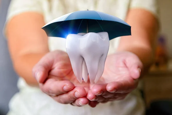 遮阳伞下的一颗牙盖住女人的手 保护健康 保险概念 — 图库照片