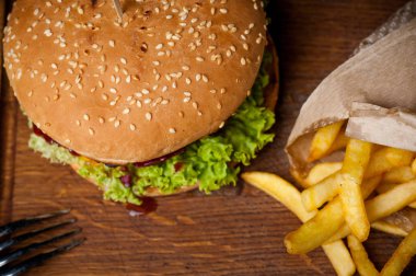 Amerikan burger ve patates kızartması bir ahşap tahta üzerinde. Üst fotoğraf.
