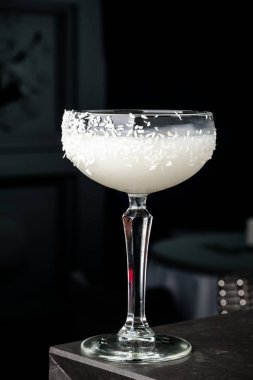 Barmen Hindistan cevizi ve buz bir kokteyl yapar. Makro, siyah arka plan, el, beyaz