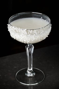 Barmen Hindistan cevizi ve buz bir kokteyl yapar. Makro, siyah arka plan, el, beyaz