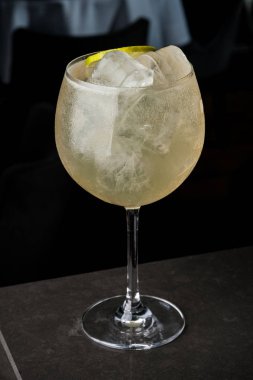 bir barmen bir yaz buz ve kireç kokteyl yapar. Makro, siyah arka plan, el, sarı, damla cam, bubbles