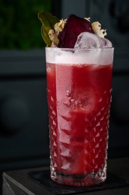 Köpük, pancar ve nane bir soğuk cam bar siyah bir arka plan üzerinde kırmızı kokteyl. damla, çiğ ve buz, kırmızı pancar