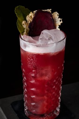 Köpük, pancar ve nane bir soğuk cam bar siyah bir arka plan üzerinde kırmızı kokteyl. damla, çiğ ve buz, kırmızı pancar