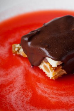 peynirli kek çikolata çilek kırmızı şurubu ile beyaz plaka ile. Makro fotoğraf Çiy damlaları.