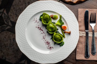 Bıldırcın yumurta ile yeşil mantı. Cadılar Bayramı. Siyah tuğla duvar arka plan ve ahşap masa