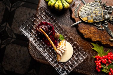 Siyah bir zemin üzerine geyik biftek. Cadılar Bayramı kutlamaları için bir restoranda bir yemek. Siyah arka plan, tuğla duvar ve ahşap masa