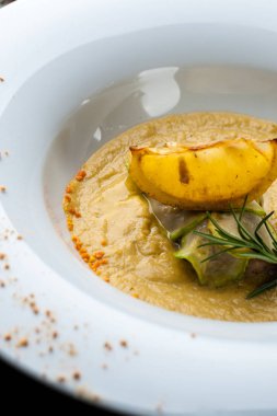 Som balık ile kabak krem çorbası Cadılar Bayramı kutlamaları için bir restoranda bir yemek. Siyah arka plan, tuğla duvar ve ahşap masa