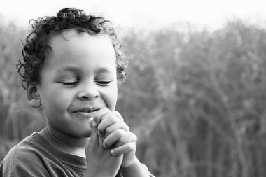 little boy praying to God stock image with hands held together stock photo