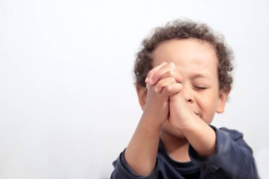 boy praying to God stock image with hands held together with closed eyes with people stock photography stock photo