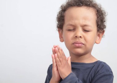 Tanrı 'ya dua eden çocuk elleri kapalı, gözleri kapalı, stoktaki fotoğrafçılarla fotoğraf çekiniyor.