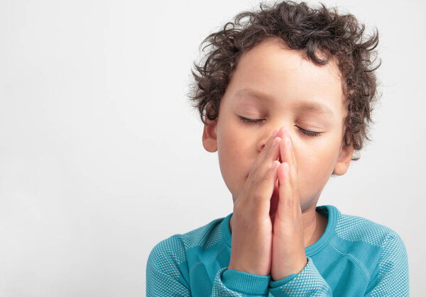 boy praying to god with hands together stock photo 