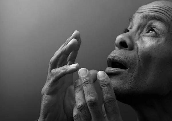 black man praying to god with black grey background