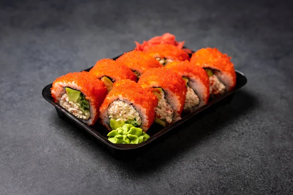 Japanese rolls with flying fish roe on dark gray background