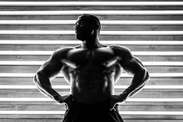 Африканский Спортсмен Демонстрирует Мышцы Фоне Деревянных Флуоресцентных Ламп Черное Белое — стоковое фото