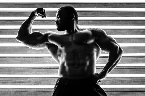 Atleta Africano Masculino Demuestra Los Músculos Sobre Fondo Madera Lámparas — Foto de Stock