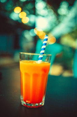 Bir bardak Aperol Spritz ve mavi pipet, İtalyan Kokteyli. İnce film tahıl dokusu.