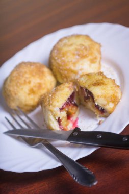 Taze erik köfte. Bir dilimlenmiş dumpling ve bıçak ve çatal koyu kırmızı masada beyaz tabakta ile iki tüm.