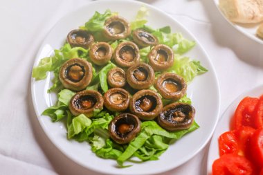 Yeşil salata ile beyaz tabak içinde mantar kızartma. Düğün masa dekorasyon Restoran.