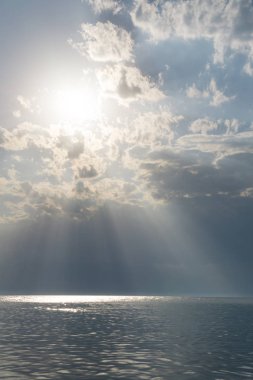 Deniz suyu bulutlu gün, Doğa arka plan. Bulutların arasından güneş ışınlarının kır. Okyanus manzaralı bulutlu yaz gününde.