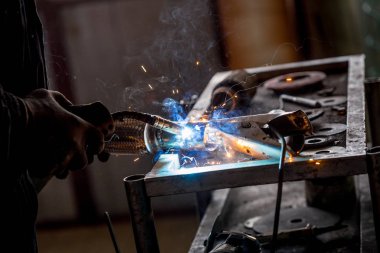 Erkek işçi araba egzoz boru kaynak makinesi ile kısayollarımı koruyucu eldivenler